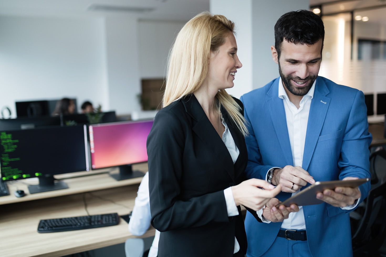 two people smiling looking at tablet computer